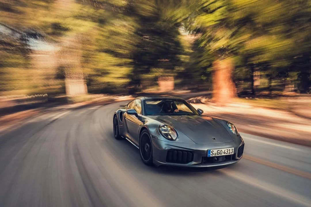 Porsche 911 Turbo S driving through autumn forest